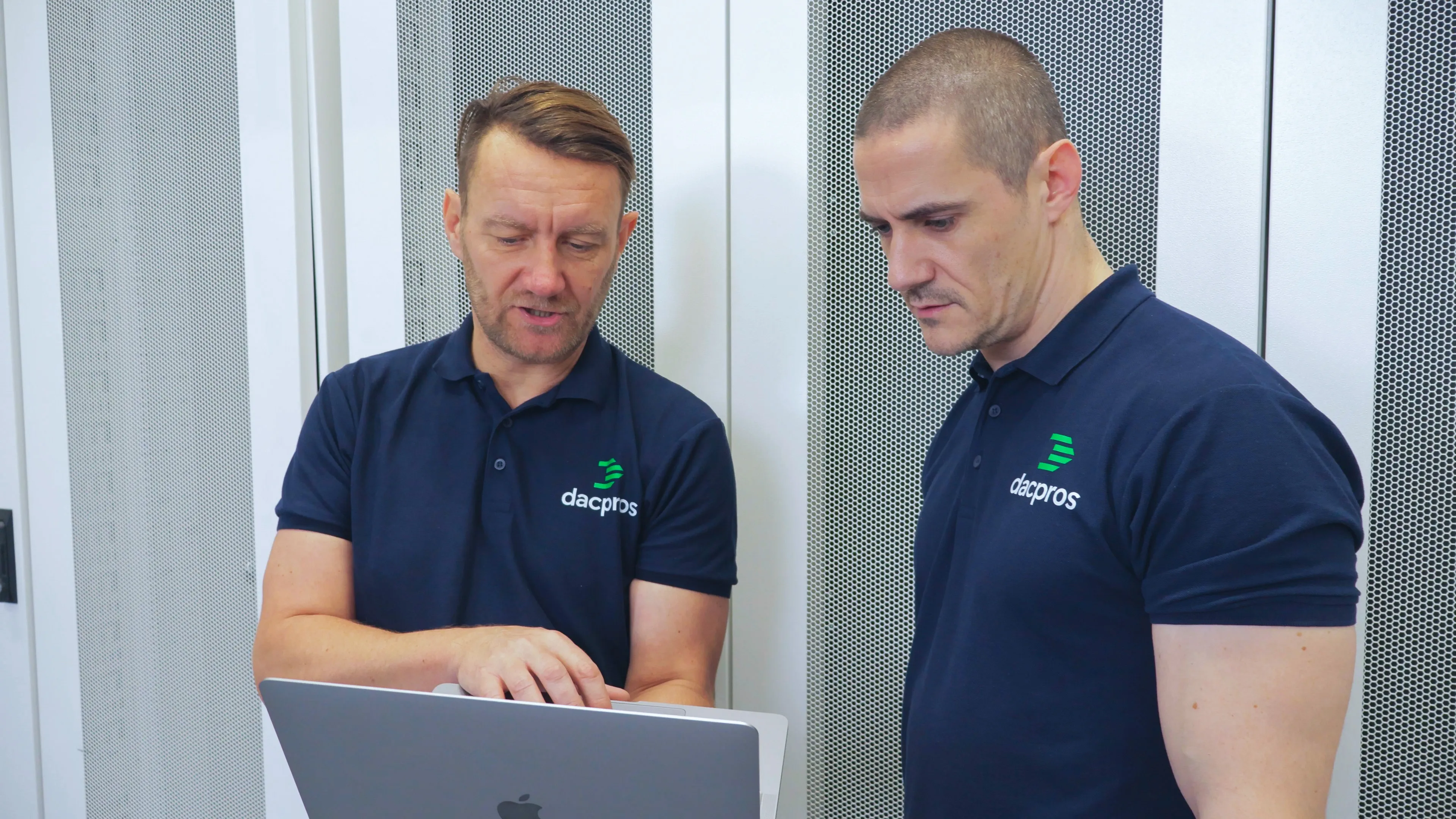 Two DACPROS engineers collaborating at a server rack