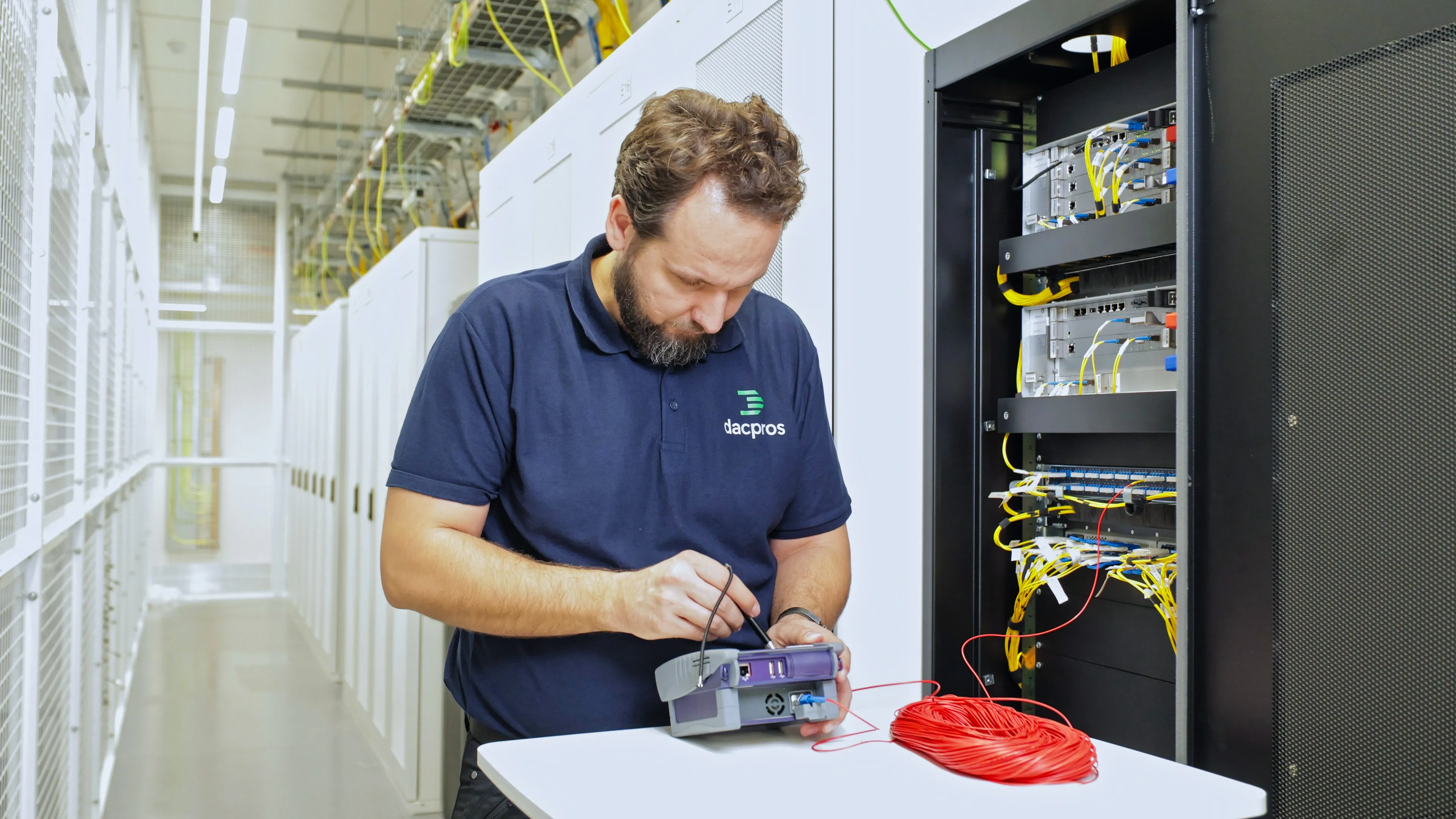 DACPROS engineer using OTDR fibre testing equipment at a data centre